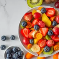 Summer,Fresh,Fruit,Salad,In,A,Bowl,On,White,Marble